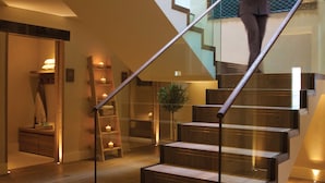 A modern staircase with glass railings and wooden steps, leading to a second floor. - The Swan Hotel (Sudbury)