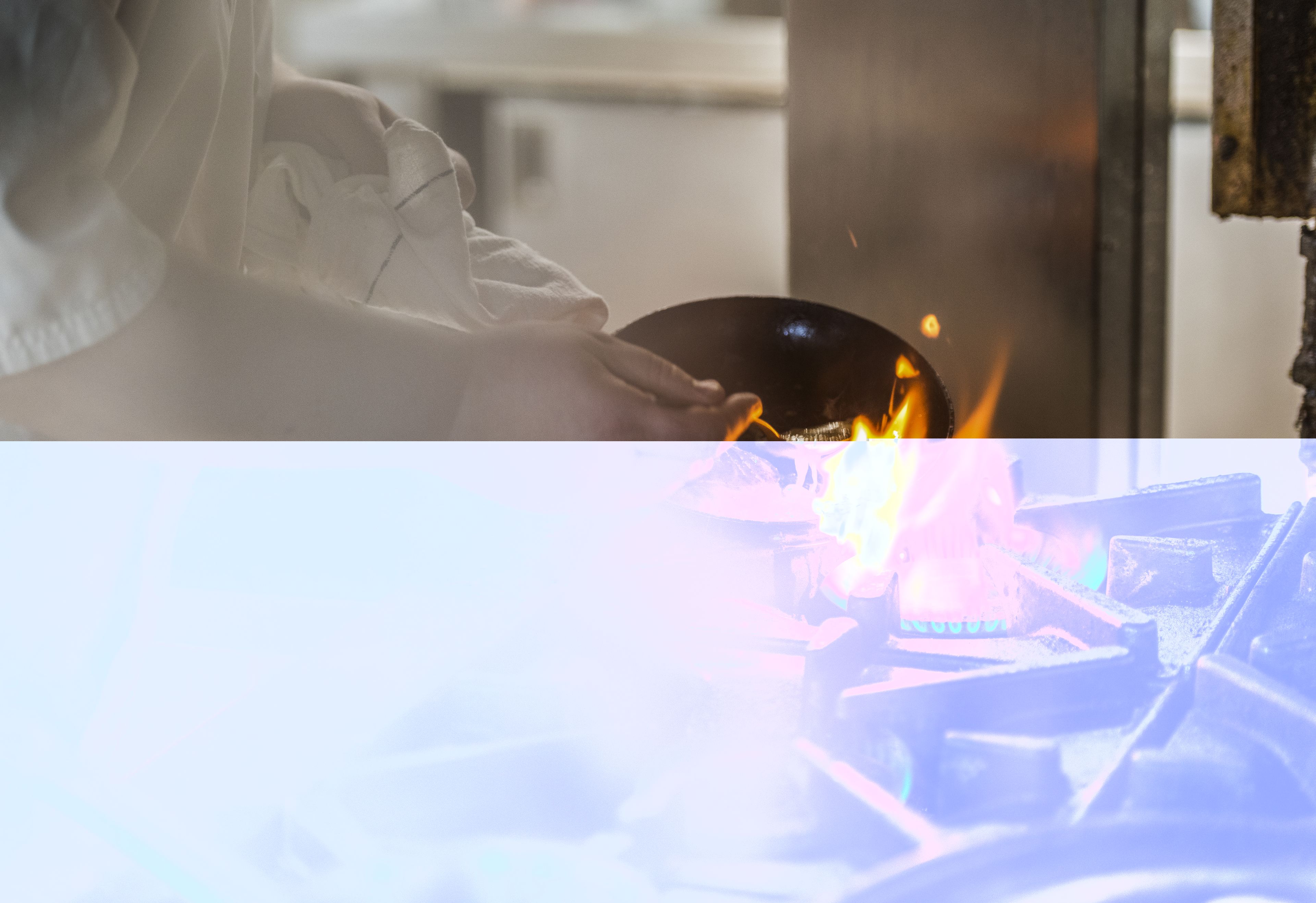 Eine Person hält eine schwarze Schüssel über einer Flamme, unscharfer Hintergrund.