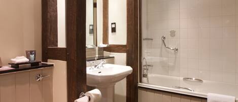 A modern bathroom with a toilet, sink, and bathtub.