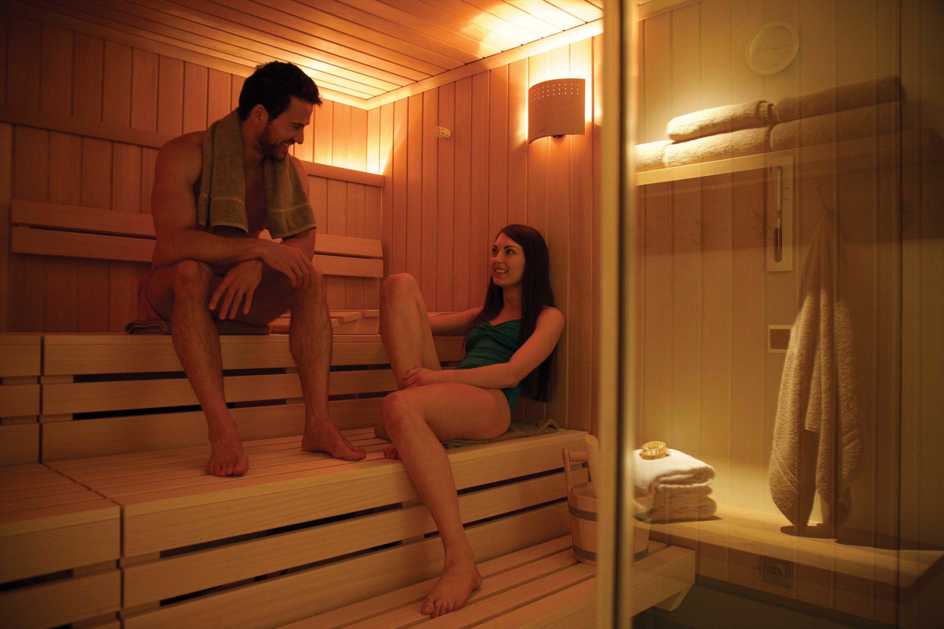 Una sauna con bancos de madera y un panel de vidrio.
