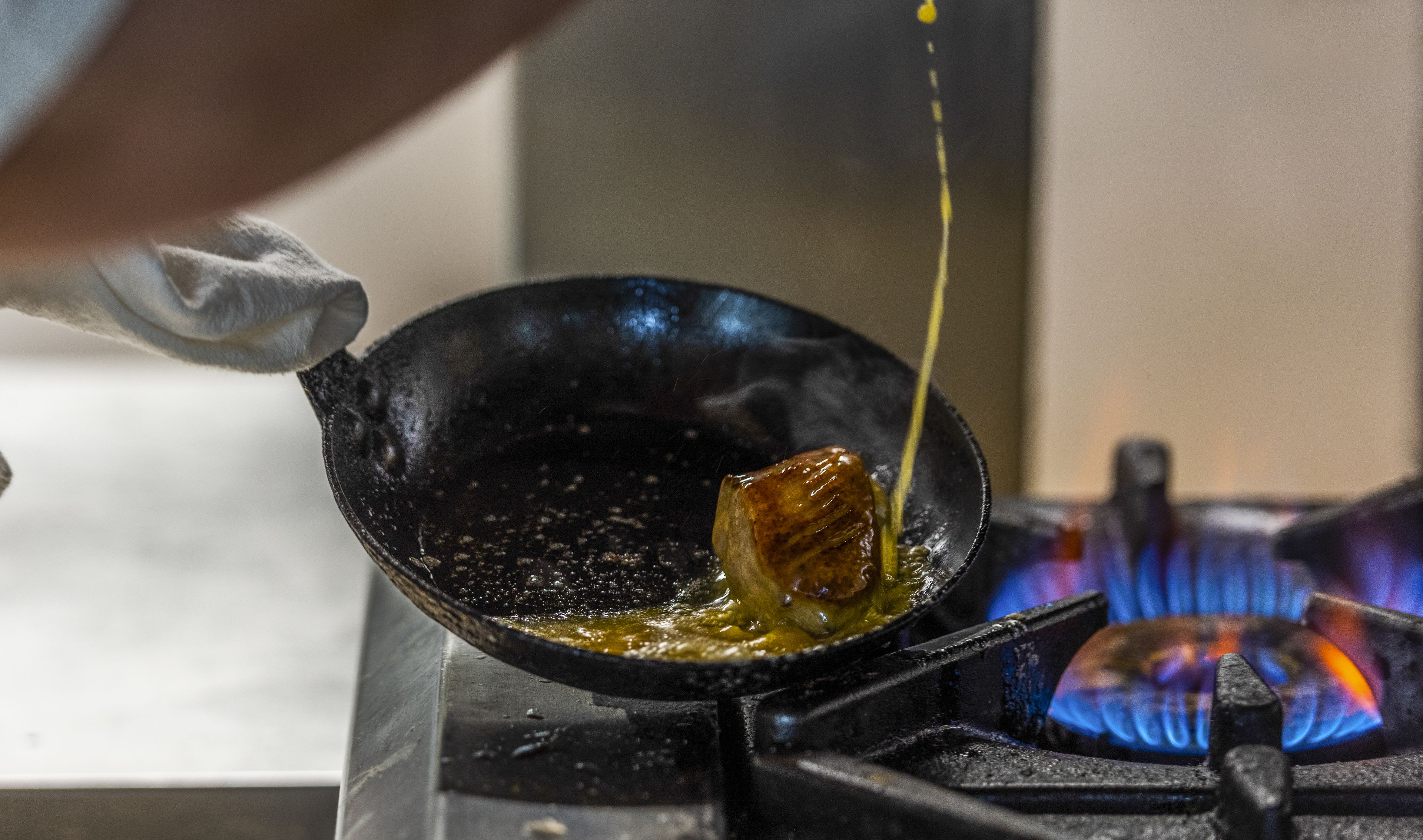 A close-up of a cooking process with a pan on a stove.