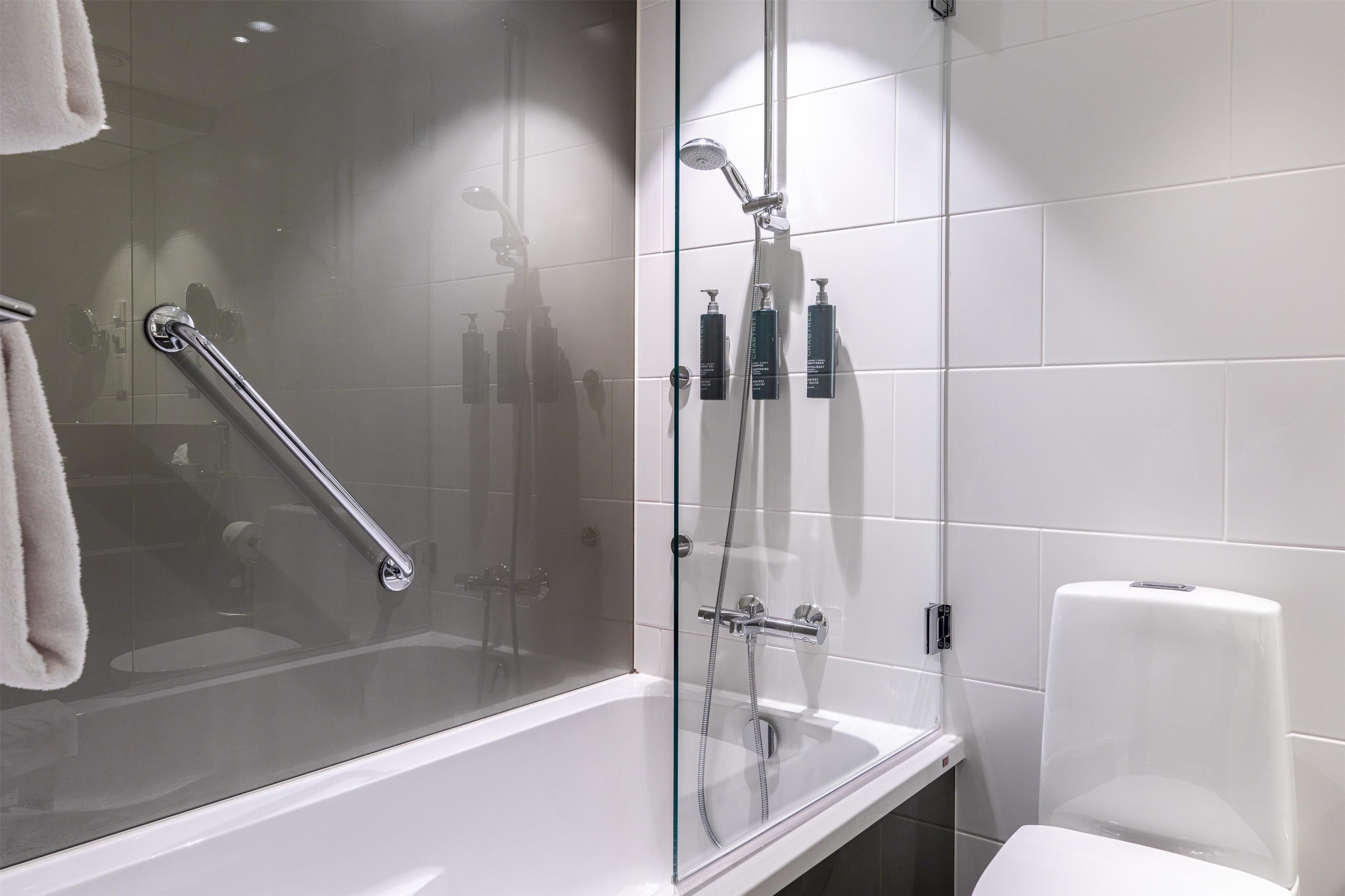 Une salle de bain moderne avec une douche à parois de verre, une baignoire blanche et des toilettes blanches.