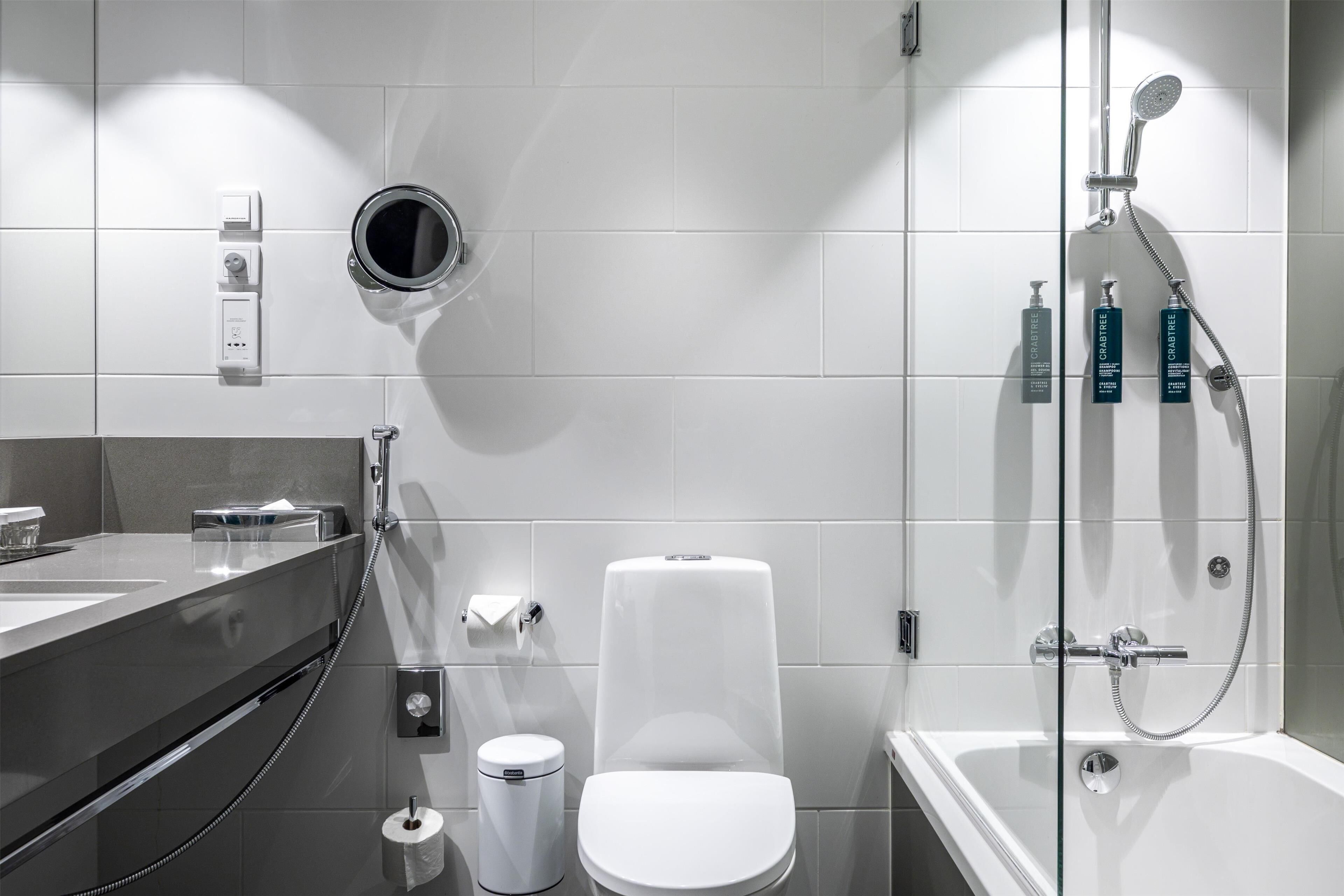 A modern bathroom with a toilet, bidet, and shower.