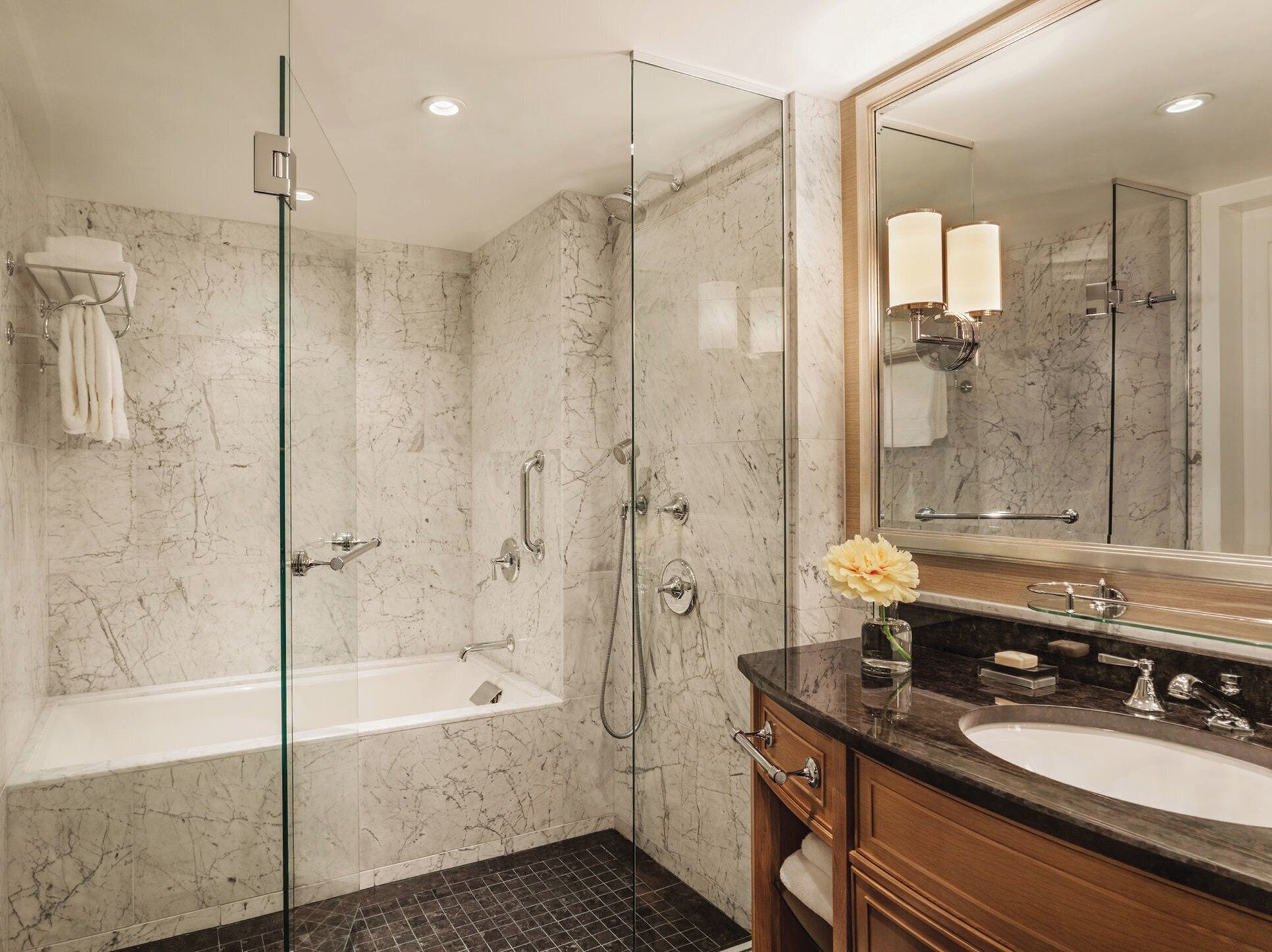 Une salle de bain moderne dotée d’une douche à parois de verre, d’une baignoire et d’un meuble-lavabo avec un évier et un miroir.