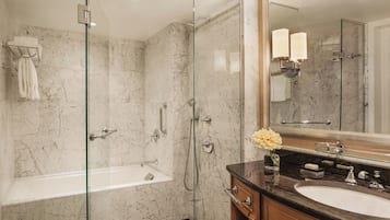 Une salle de bain moderne dotée d’une douche à parois de verre, d’une baignoire et d’un meuble-lavabo avec un évier et un miroir.