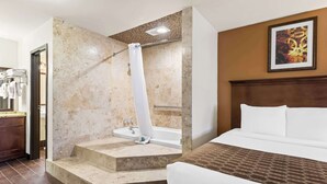 A hotel room with a bed, a bathroom with a bathtub, and a shower. - Best Western Tower West Lodge (Gillette)