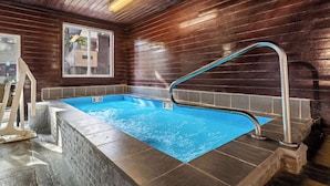 A hot tub with a wooden interior, a window, and a metal ladder. - Best Western Tower West Lodge (Gillette)