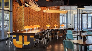 A modern bar area with a unique wooden wall, multiple bar stools, and ambient lighting.