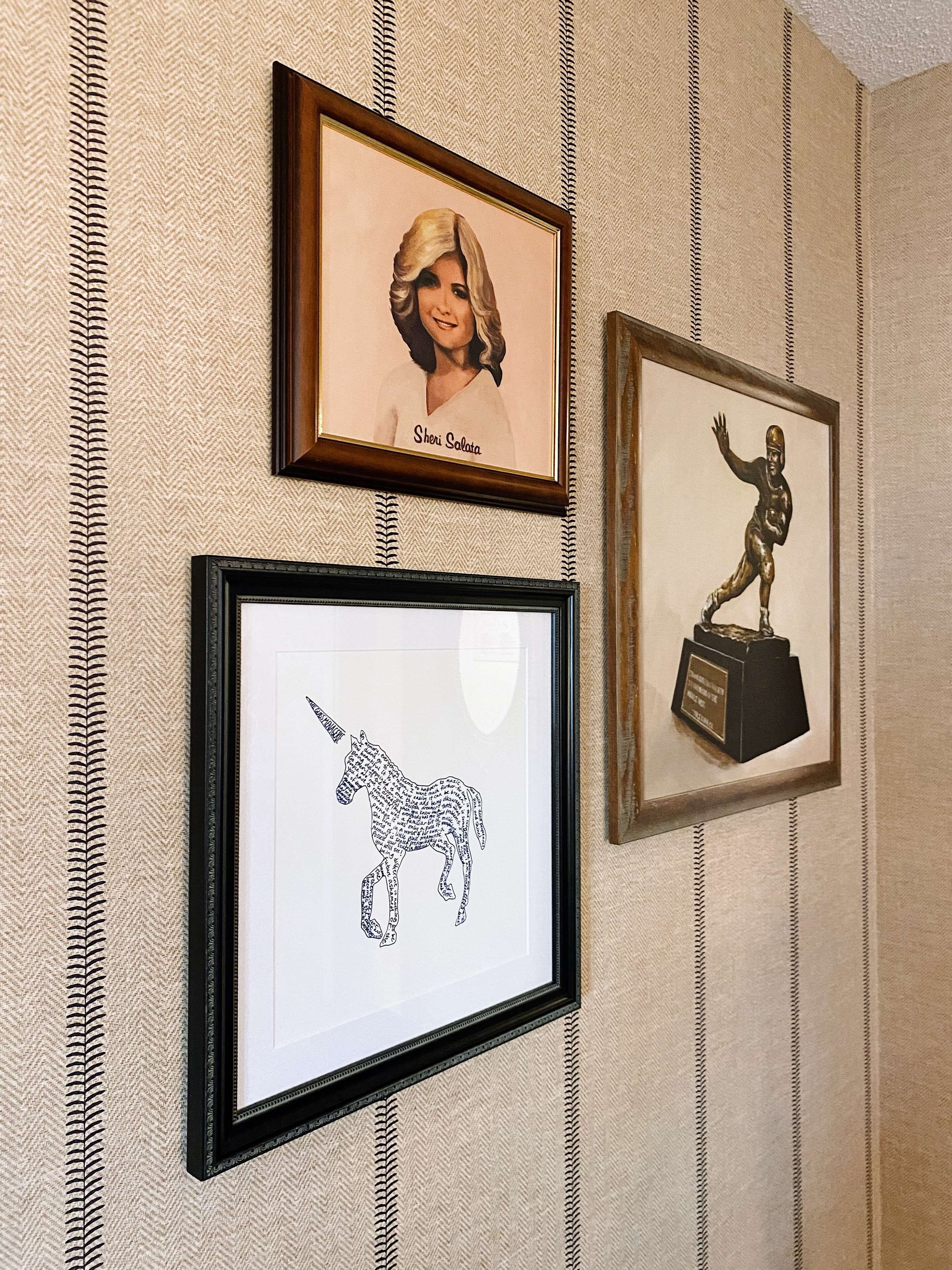 Three framed pictures on a wall with a herringbone pattern.