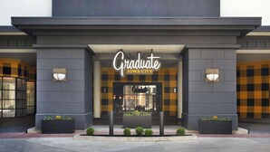 A hotel entrance with a sign reading "Graduate Iowa City." - Graduate by Hilton Iowa City (Iowa City)