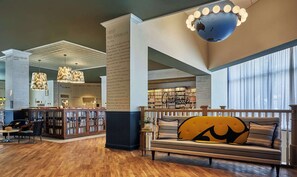Una biblioteca amplia con estanterías, un rincón de lectura con sofá y un gran globo colgando del techo.