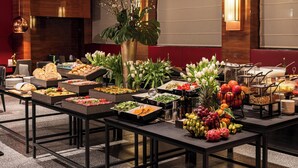 A buffet with various food items and a decorative plant.