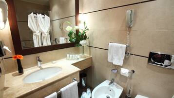Un bagno moderno con uno specchio grande, due lavabi, un bidet e un telefono.