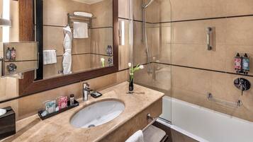 Un bagno moderno con un ampio specchio, un lavandino, una doccia e una vasca da bagno.