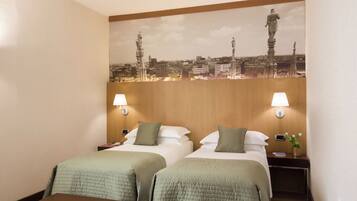 Een hotelkamer met twee bedden, een houten hoofdbord, een stadslandschap muurschildering, twee bedlampen en een nachtkastje met een bloevas.