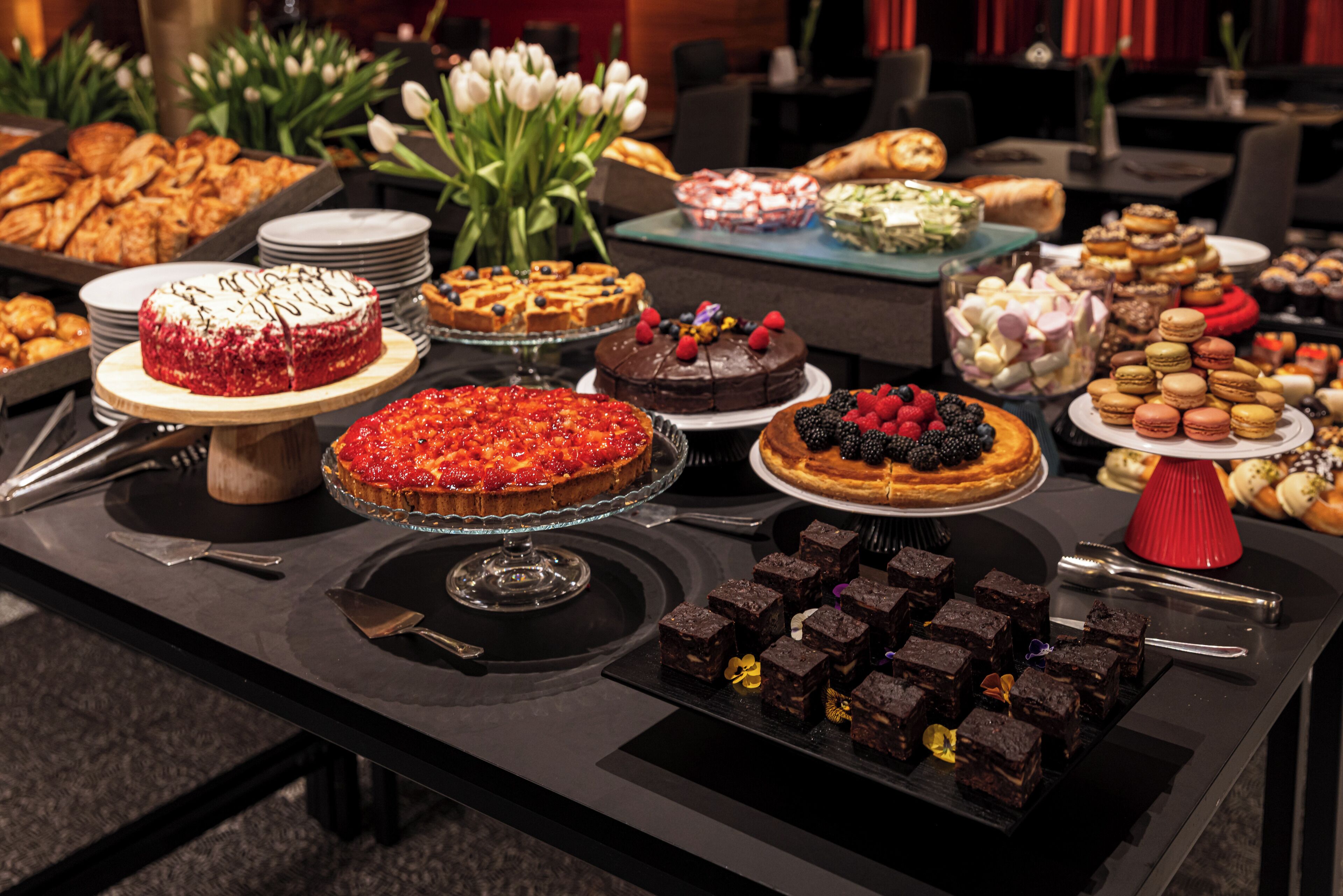Una mesa de bufé con diversos postres y pasteles.