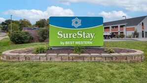Letrero de SureStay by Best Western con un jardín paisajístico al frente.