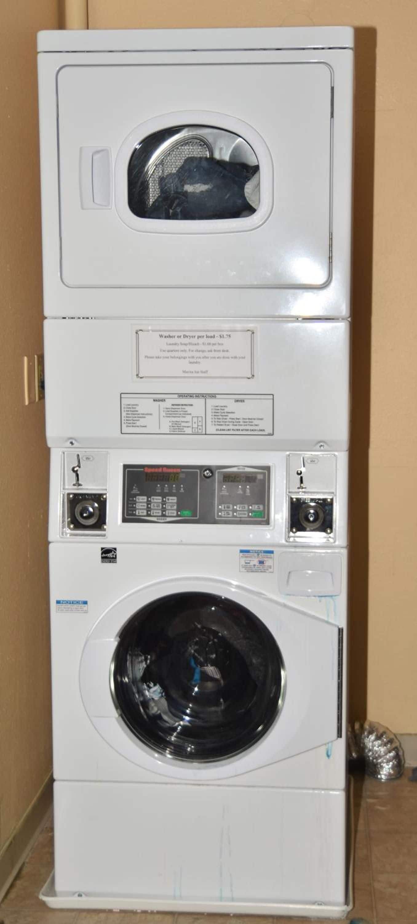 Una lavadora y secadora apiladas con un panel de control y una lavadora de carga frontal.
