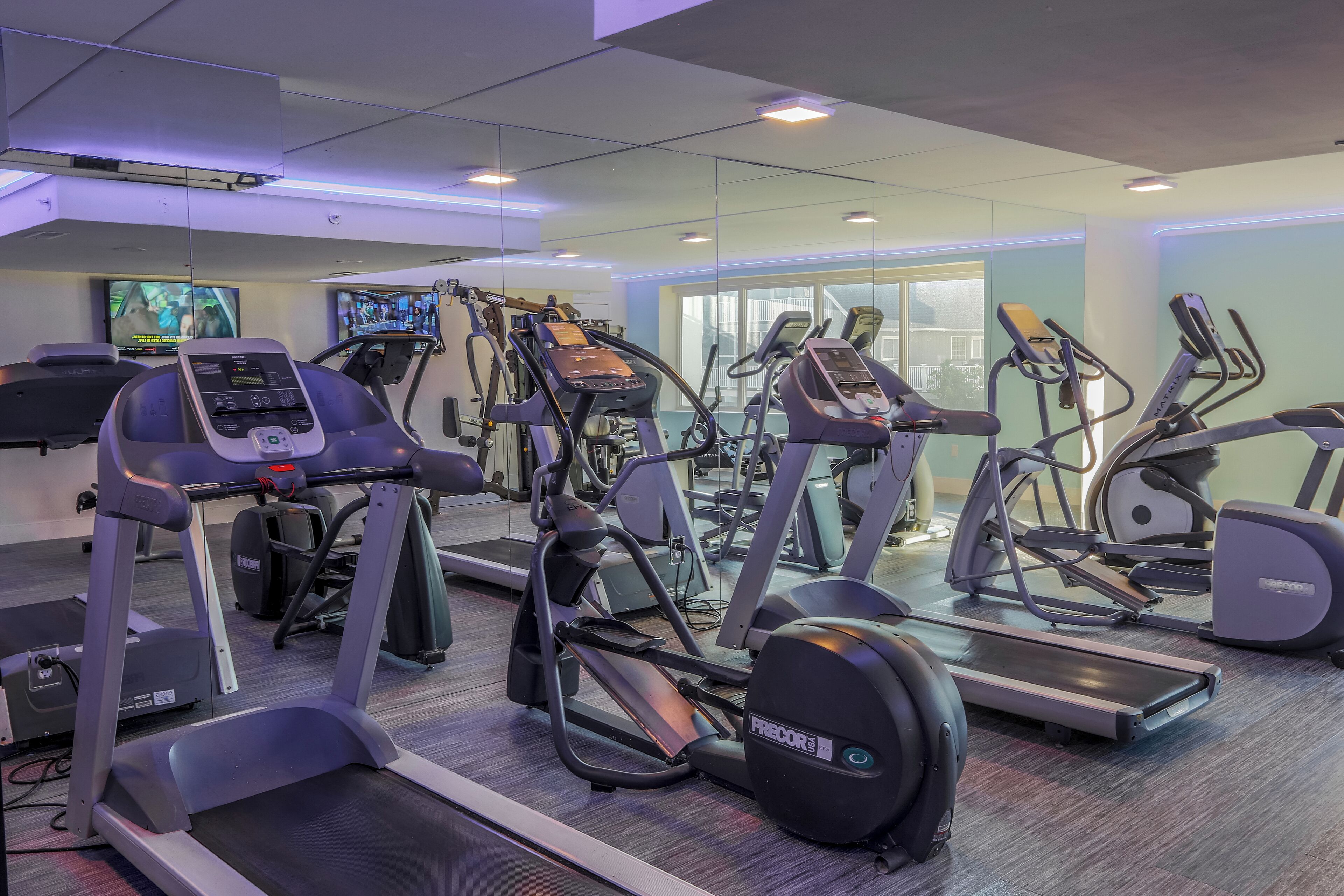 Et fitnesscenter med løbebånd, crosstrainere og spinningcykler.