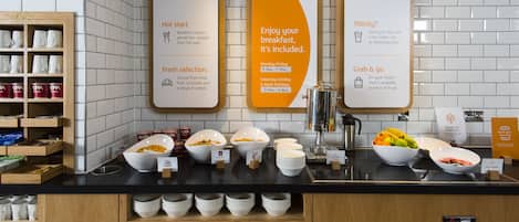 A breakfast buffet with signs indicating hot start, fresh selection, and grab & go options.
