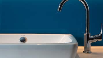 A modern bathroom with a white sink and a chrome faucet.