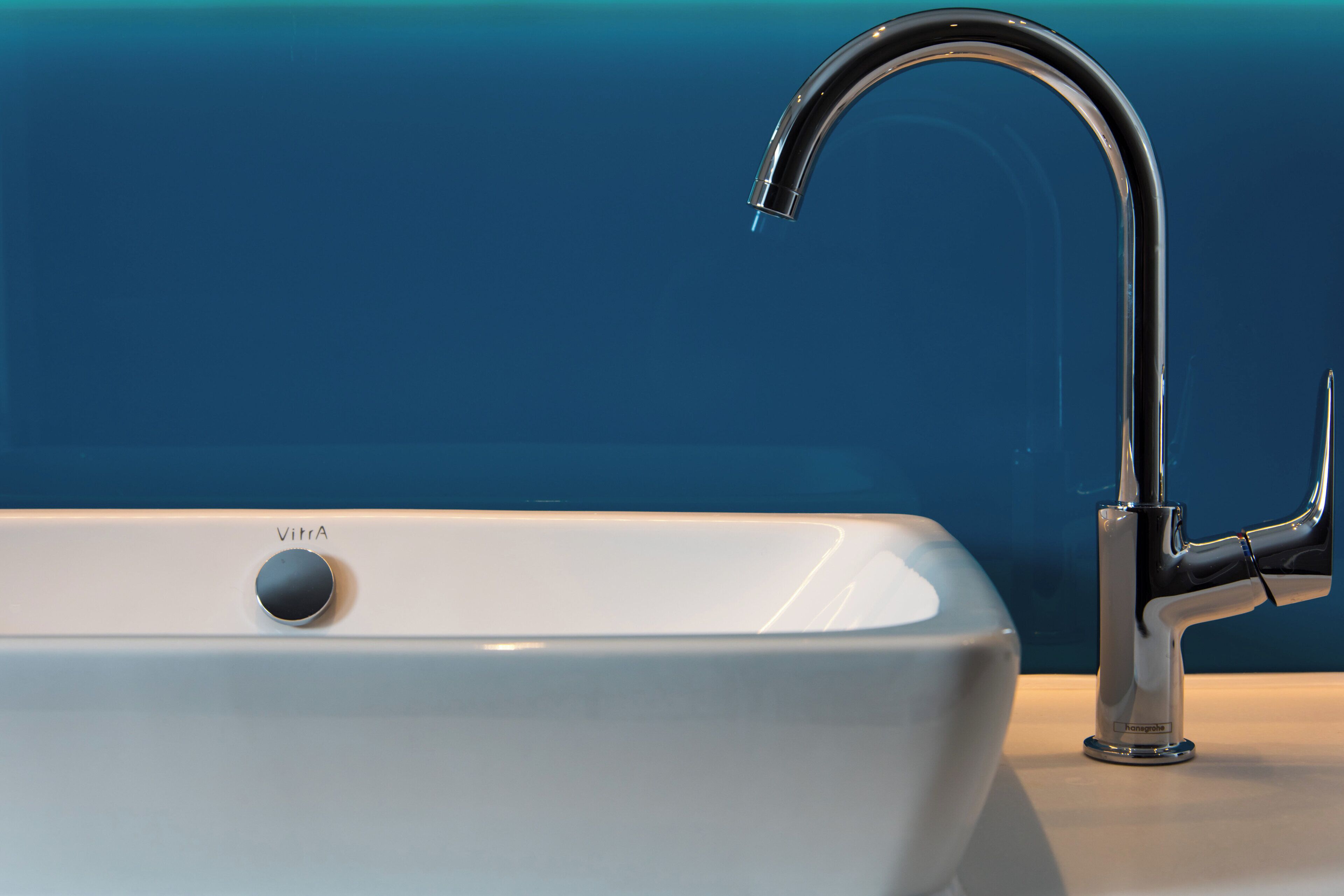 A modern bathroom with a white sink and a chrome faucet.