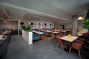A modern restaurant interior with multiple seating options, including booths and tables, and a counter area for food service. - Leonardo Hotel Galway (Galway)