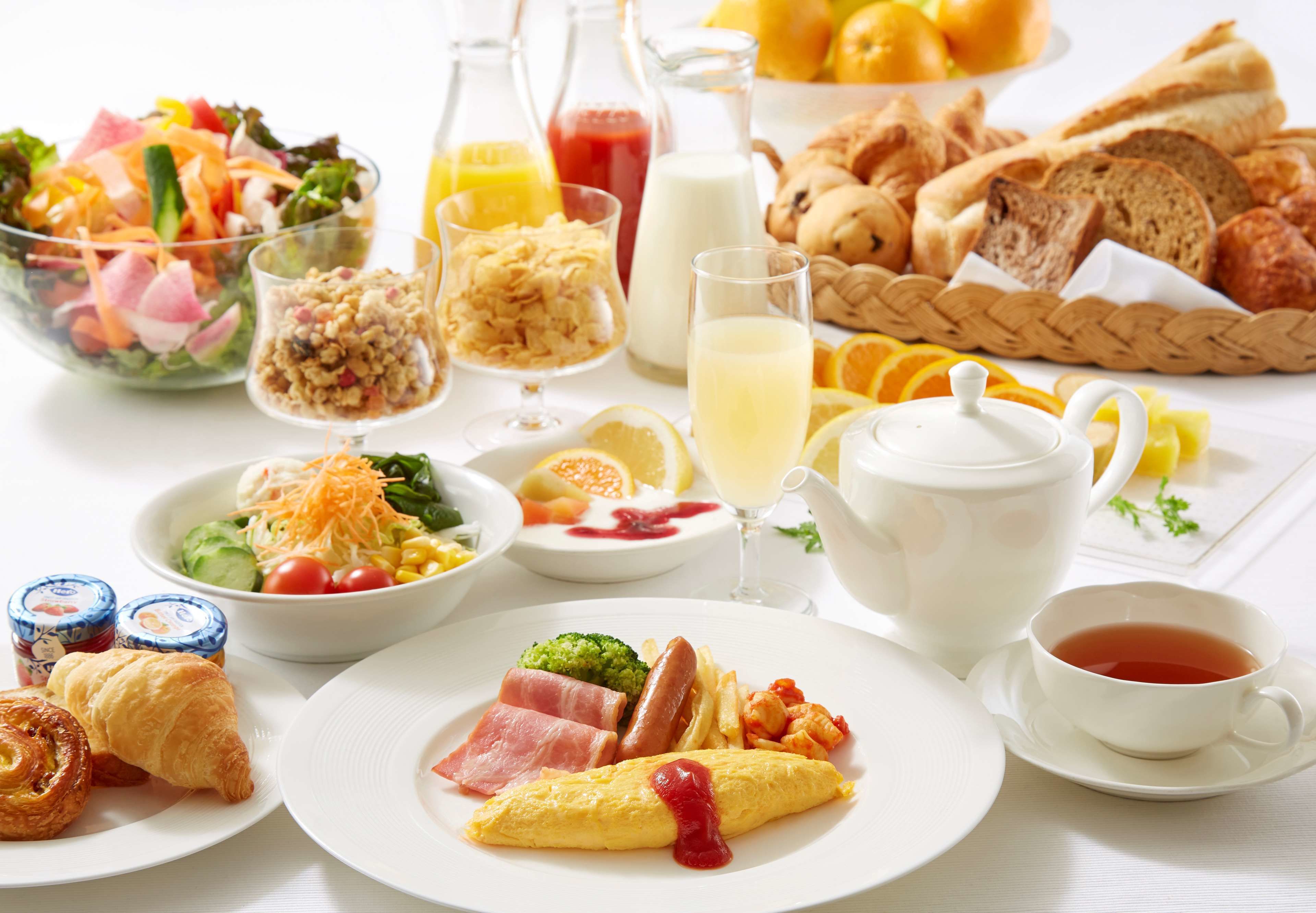 A breakfast table with various dishes including eggs, toast, and a salad.
