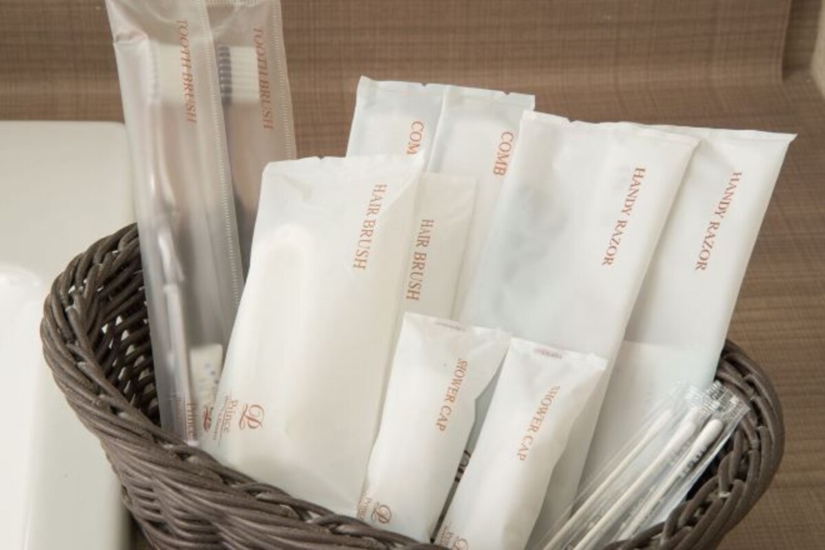 A wicker basket containing several white packages labeled "Hair Brush" and "Comb."