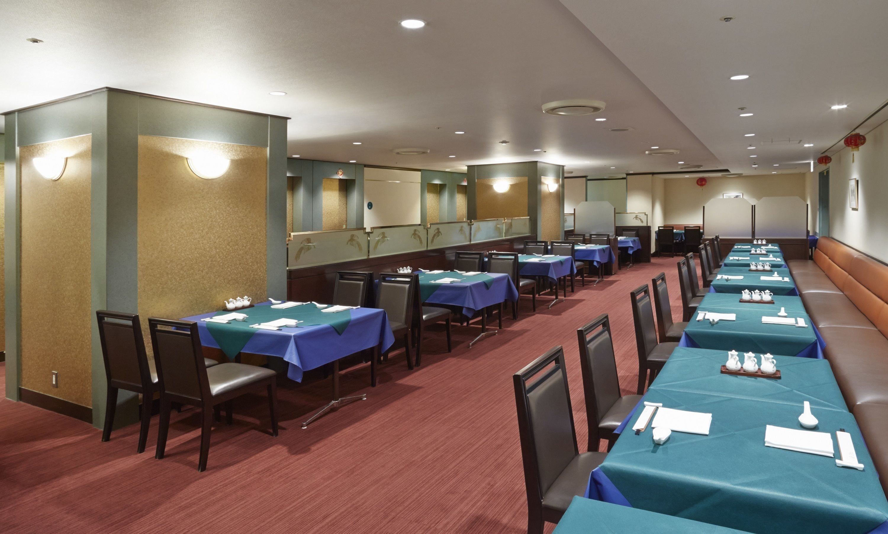 Une salle de conférence avec des rangées de tables, des chaises et une estrade.