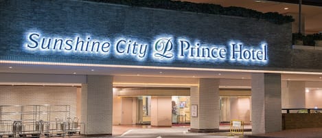 The Sunshine City Prince Hotel entrance with a brick facade and illuminated signage.