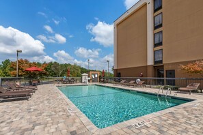 Relax by the pool surrounded by lounge chairs and umbrellas.