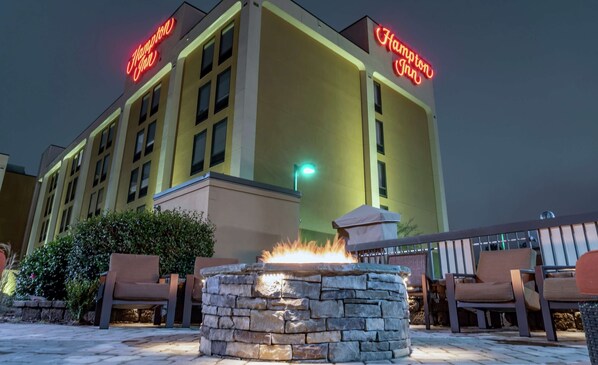 Experience the Hampton Inn's sleek design, featuring a flat roof and exterior seating areas with a fire pit.