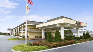 A hotel with a covered outdoor area, multiple balconies, and a clear sky. - Super 8 by Wyndham Calhoun (Calhoun)