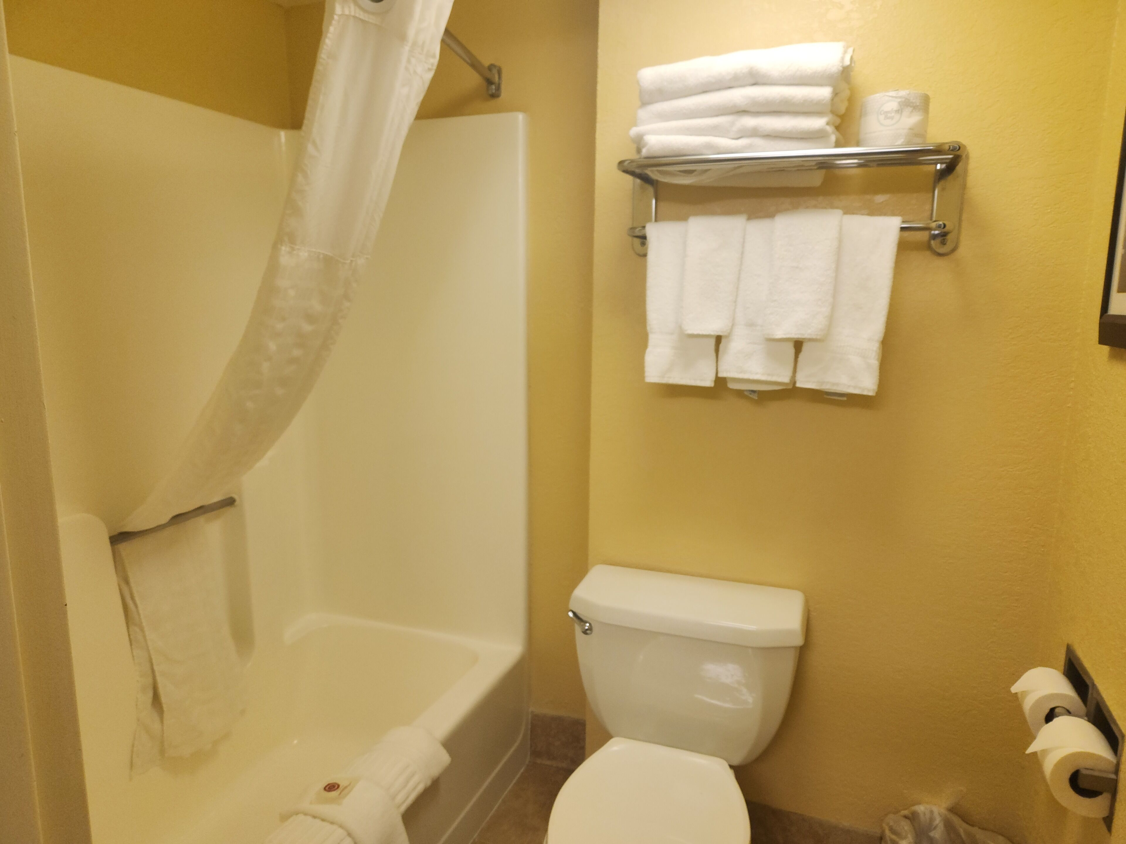 A bathroom with a bathtub, toilet, and towel rack.