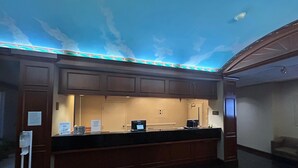 A reception area with a counter, a computer, and a sign indicating a 50-pound weight limit. - Best Western Chocolate Inn at the Park (Hummelstown)