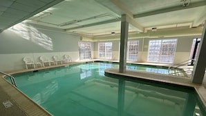 An indoor swimming pool with clear water, surrounded by white walls and windows. - Best Western Chocolate Inn at the Park (Hummelstown)