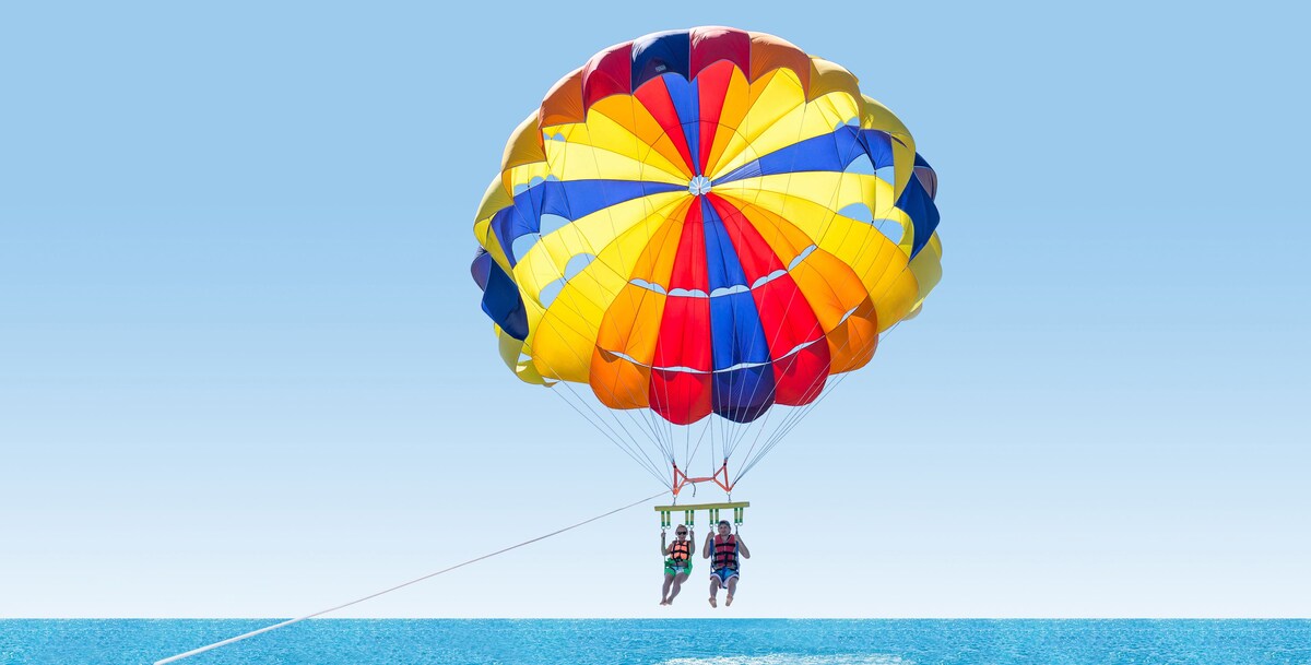 Experience the thrill of parasailing over the calm waters.