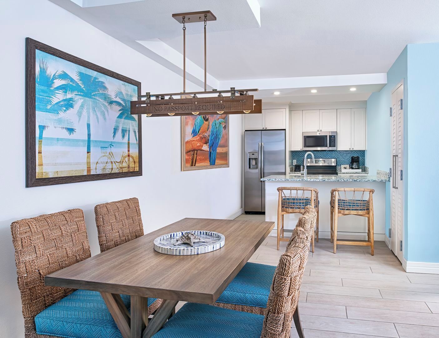 A modern kitchen with white cabinets, a stainless steel refrigerator, and a blue tiled backsplash.