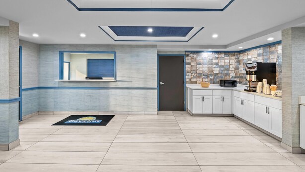 A modern kitchen with a built-in microwave, white cabinets, and a stone backsplash. - Days Inn by Wyndham Chesapeake (Chesapeake)