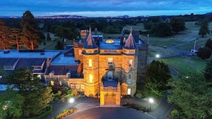 A large, historic building with multiple towers and a central courtyard, surrounded by trees and a well-maintained lawn. - Dalmahoy Hotel & Country Club (Kirknewton)