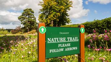 A sign for a nature trail with arrows indicating the direction to follow.