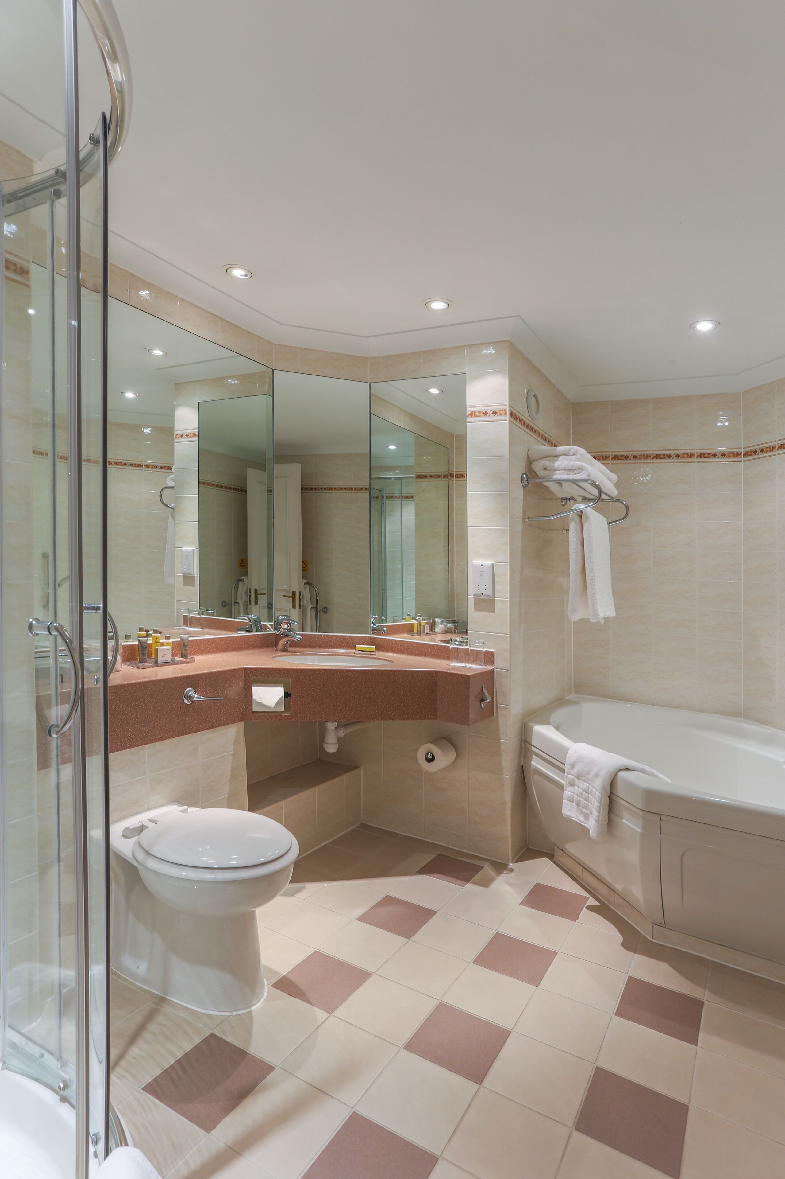 Une salle de bain moderne avec une douche à parois de verre, un lavabo avec un miroir, des toilettes et une baignoire.