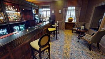 A bar area with a counter, bar stools, and a patterned carpet.