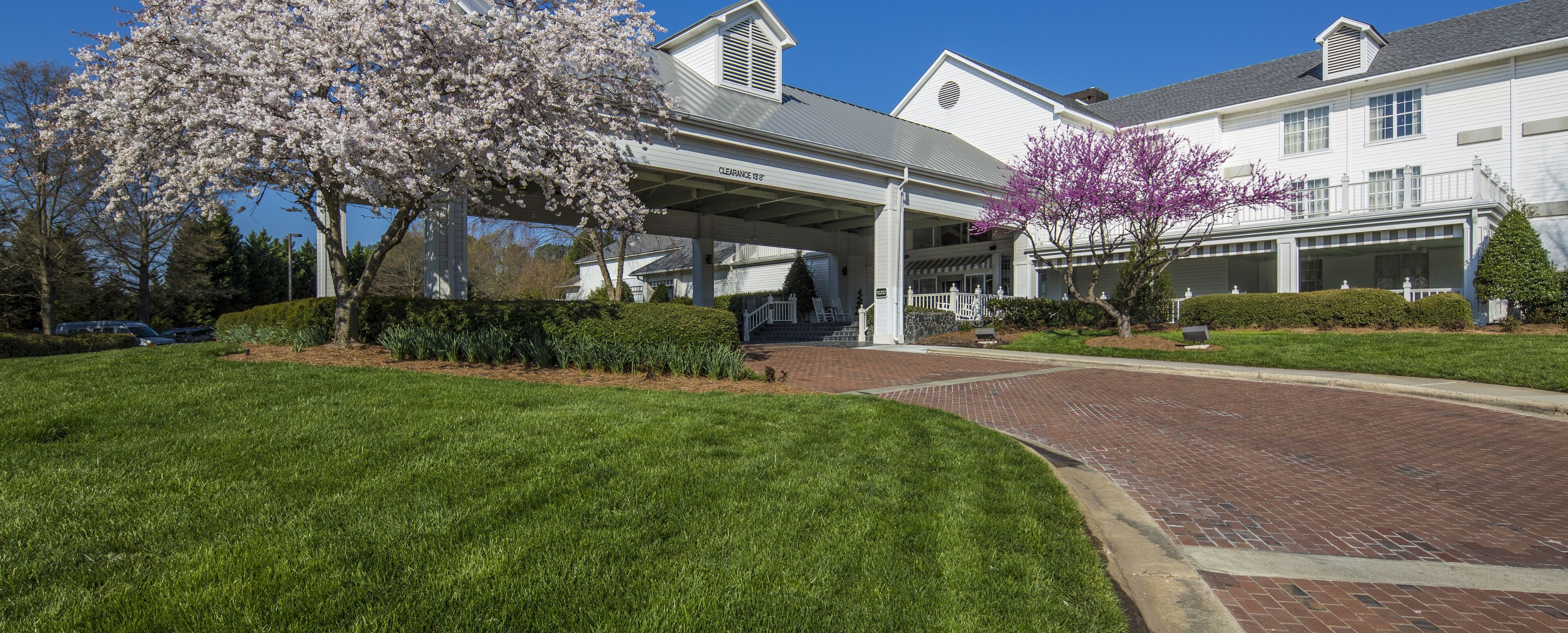 A covered walkway leading to a white building with a sign indicating a clearance of 13 feet.