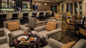 A bar area with seating, a bar counter, and a menu board.
