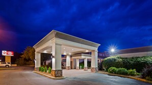 L’entrée d’un hôtel, avec un patio couvert, des colonnes et une enseigne indiquant qu’il s’agit d’un établissement Best Western Plus.