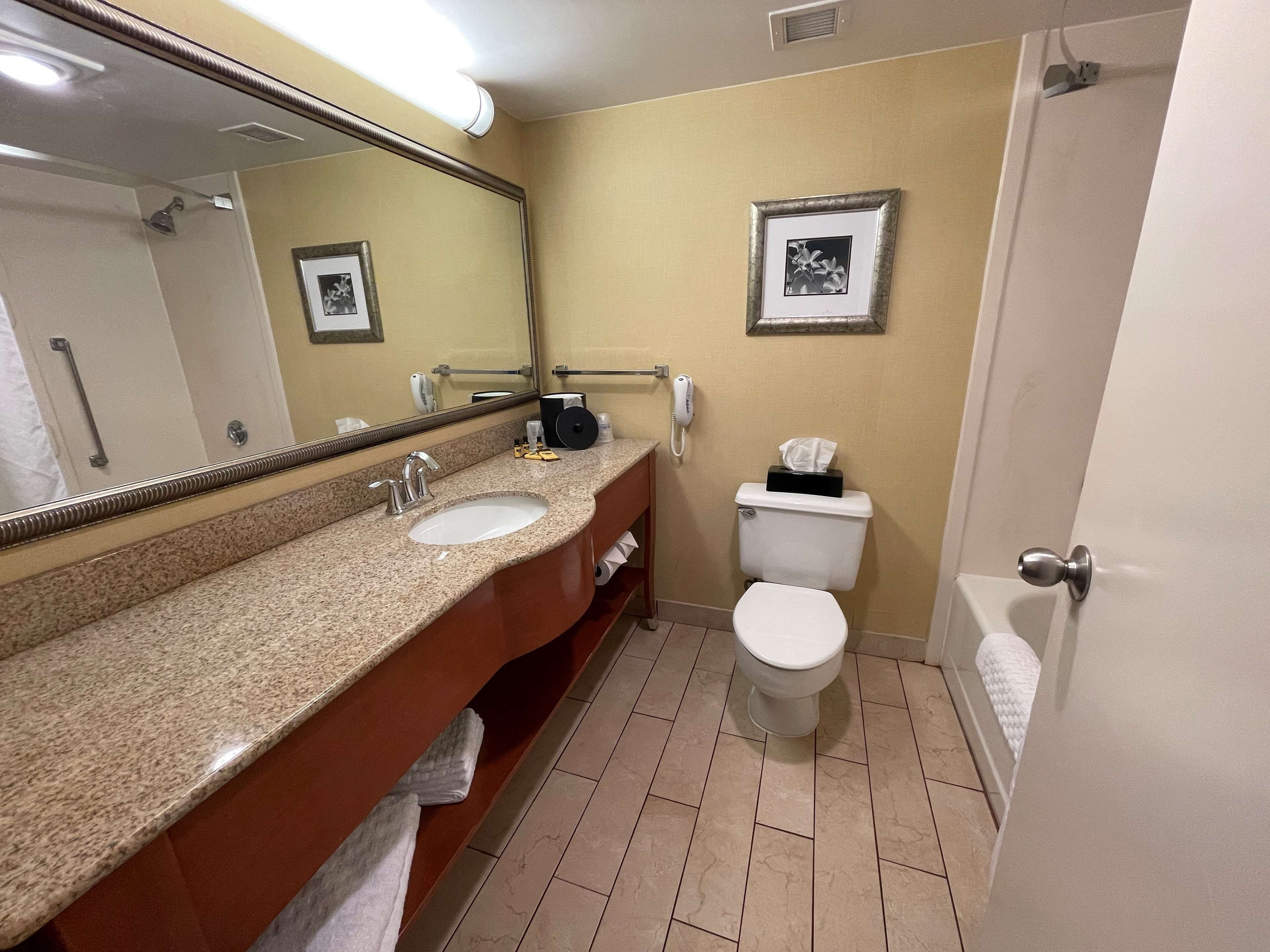 Une salle de bain avec deux lavabos, des toilettes et une douche.