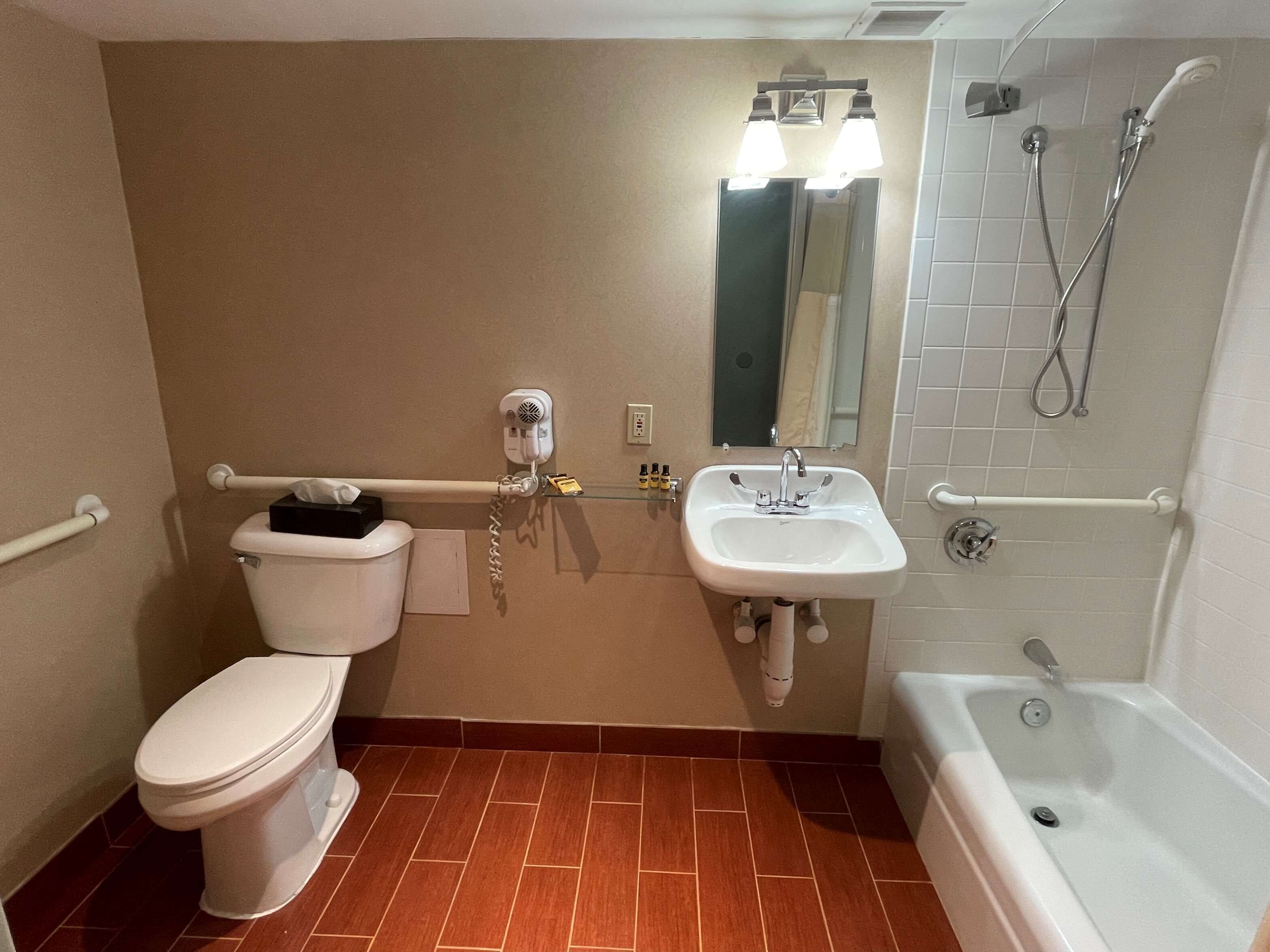 A bathroom with a toilet, sink, and bathtub.