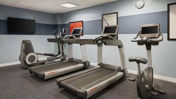 A fitness room with treadmills, a stationary bike, and a rowing machine.